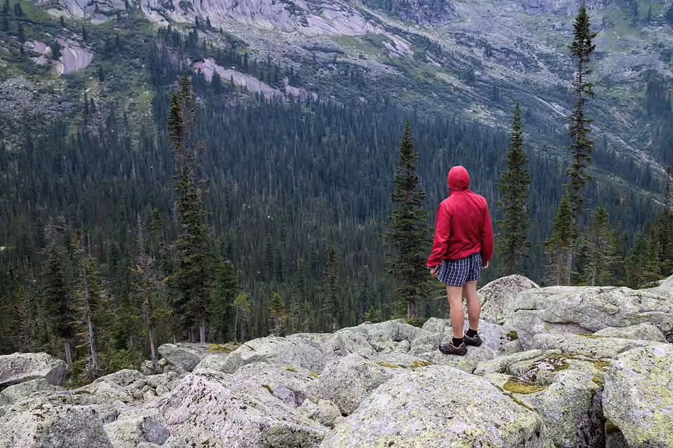 Un randonneur porte une veste coupe-vent rouge dans le massif d’Ergaki, en Sibérie.