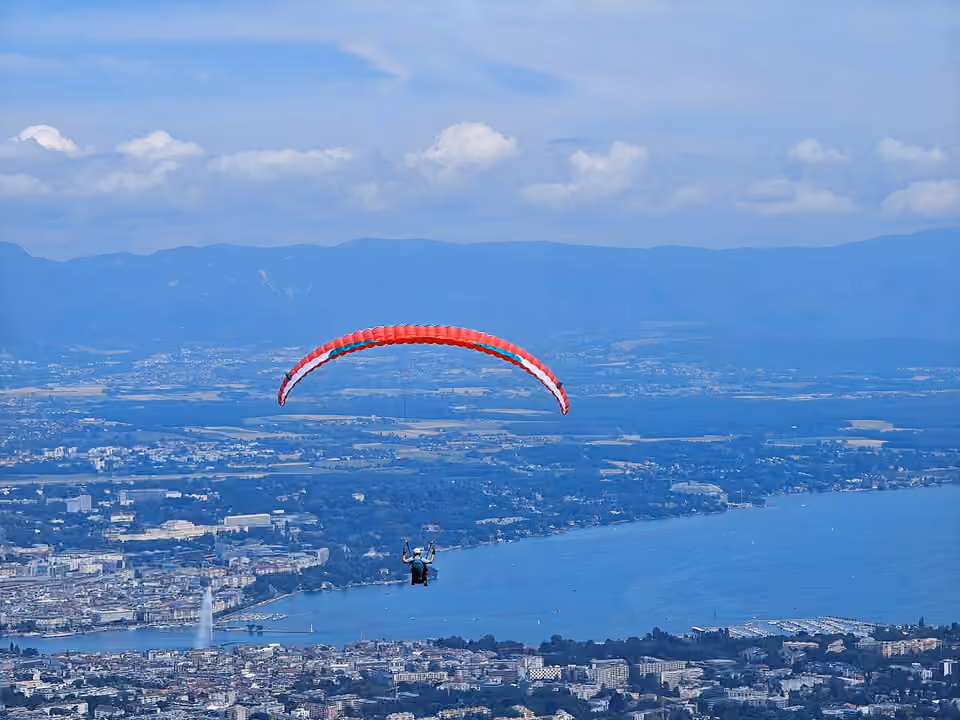 Parapentiste en vol au-dessus du lac Léman et de Genève.