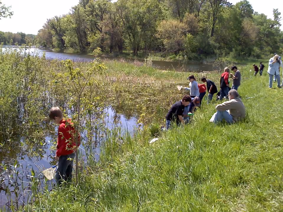 Groupe de jeunes découvrant une zone humide dans une réserve naturelle.