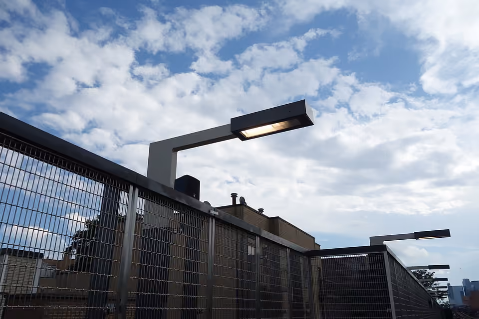 Luminaire extérieur muni d’un capot orientant la lumière vers le sol.