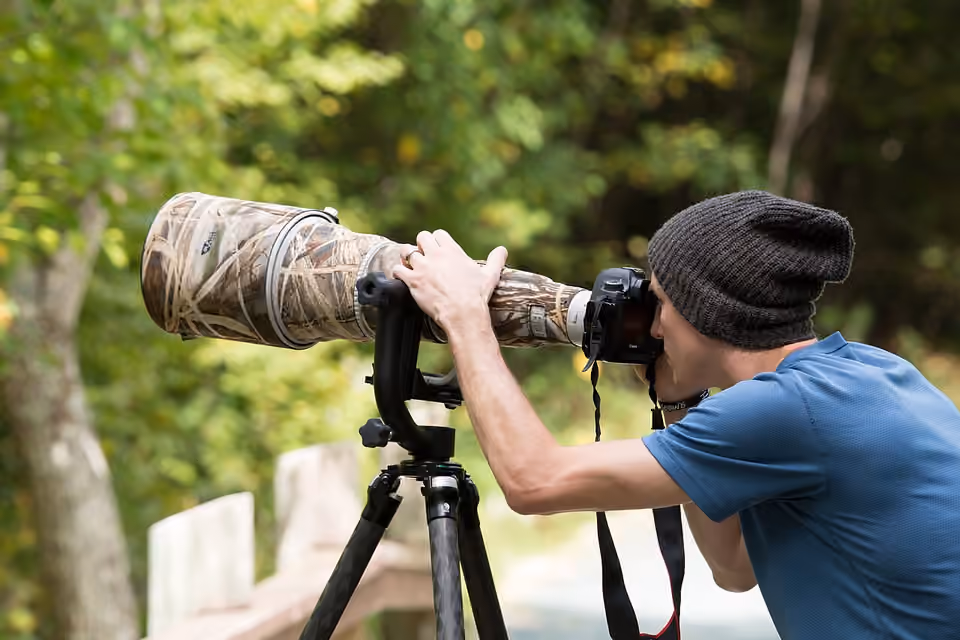 Photographe utilisant un appareil monté sur trépied en extérieur.