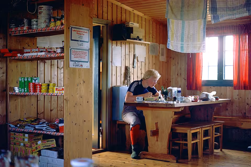 L’intérieur d’un refuge non gardé en Norvège, avec un coin cuisine et des tables.