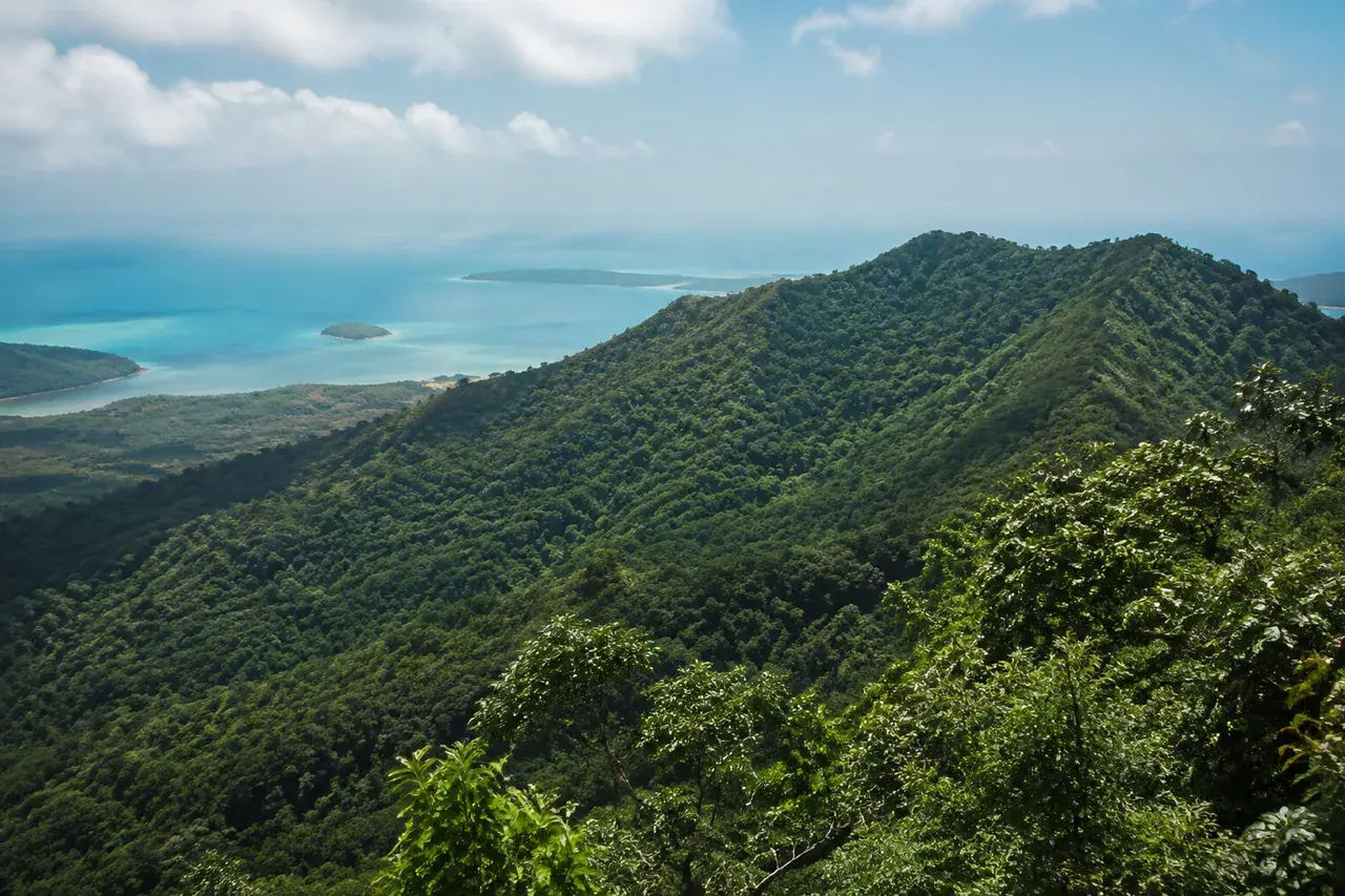 Crête volcanique boisée dominant un lagon lointain à Mayotte