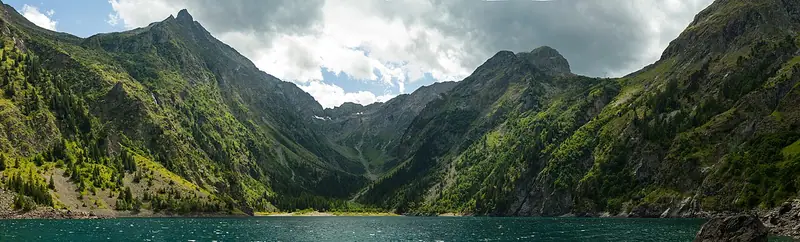 Panorama du lac du Lauvitel entouré de pentes rocheuses et de sommets.